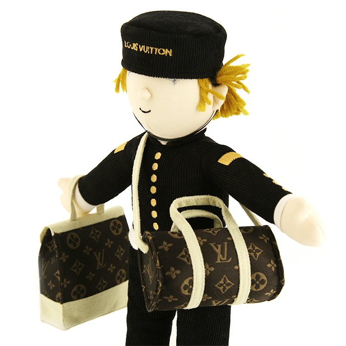 Louis Vuitton, "Le Groom", poupée, en coton, acrylique et polyester, avec deux bagages iconiques de la maison, monogrammée, dans sa boîte d'origine, des années 2000